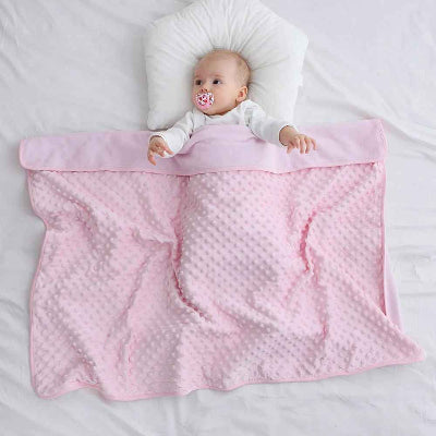 bébé avec tétine étendue sur lit sous plaid bébé