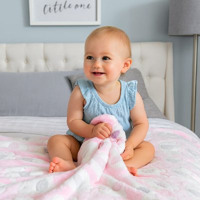 bébé fille assise sur couverture en polaire bebe rose