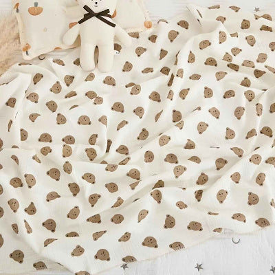 couverture emmaillotage bébé tête ours étendue sur lit enfant