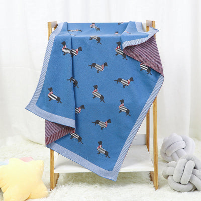 couverture bébé tricot déposée sur chaise