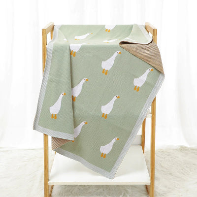 couverture bébé tricot motif canard sur chaise
