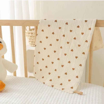 couverture emmaillotage bébé coeur suspendue sur barrière bassinette
