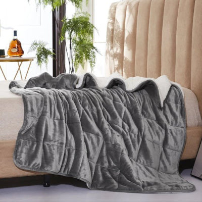 couverture lestée grise déposé sur lit