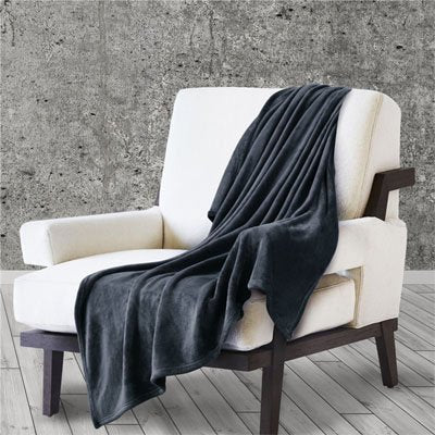 couverture noire poser en jeté sur fauteuil blanc