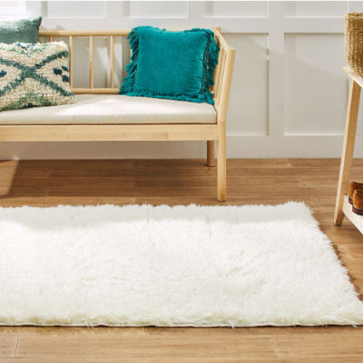 descente de lit blanche devant banc de bois