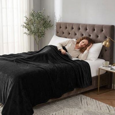 femme assoupie dans lit sous couverture