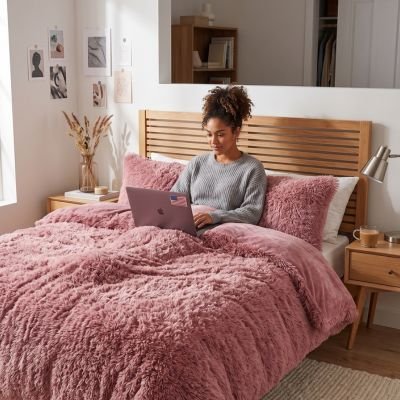 femme avec portable sous parure de lit 200x200