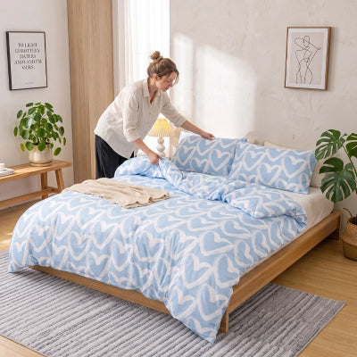 femme déposant oreiller sur parure de lit 200x200 bleu