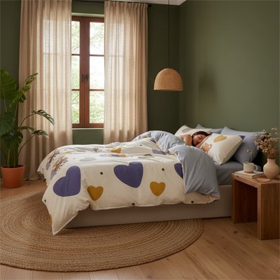 femme endormie dans chambre avec housse de couette motif coeur