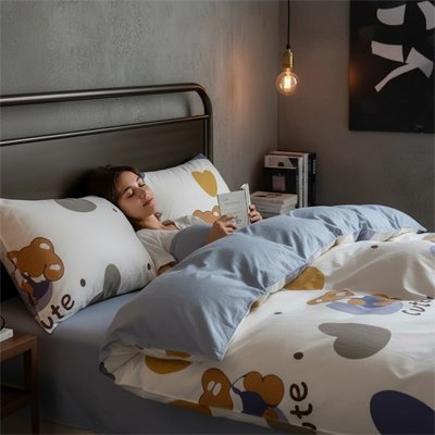 femme étendue lisant sous housse de couette motif coeur
