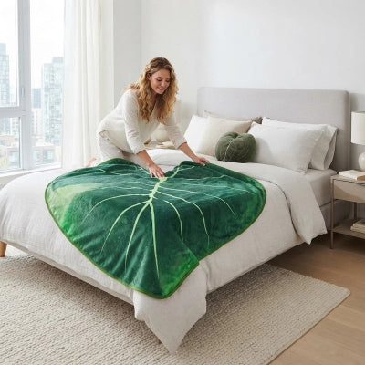 femme plaçant couvre lit feuille tropicale sur lit