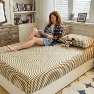 femme regardant une revue assise sur drap housse