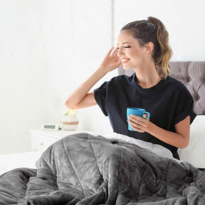 femme reposée souriante au matin avec couverture lestée