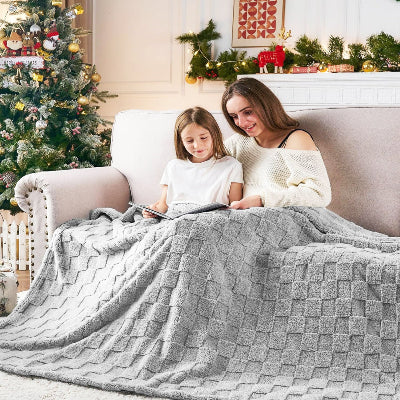 fillette et maman regardant livre sous plaid enfant