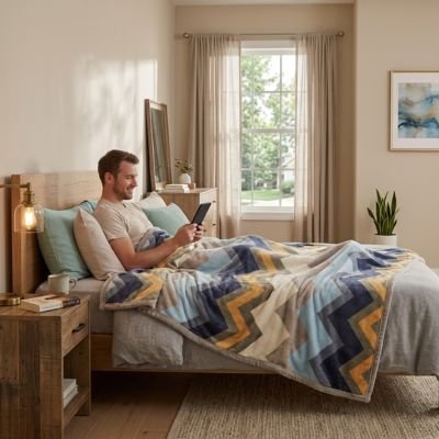 homme dans lit avec tablette sous couverture polaire