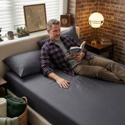 homme faisant lecture sur draps housse