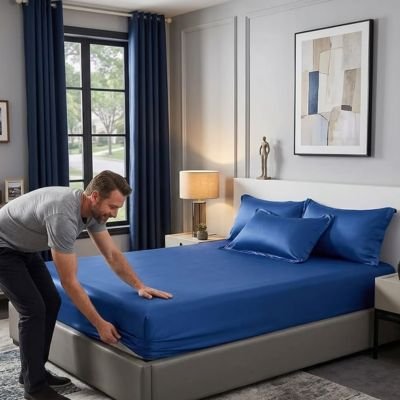 homme faisant son lit avec draps housse
