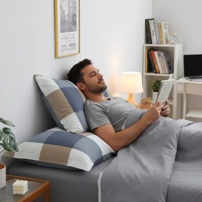 homme lisant un livre adossé sur taie doreiller