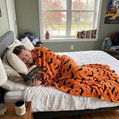 homme relaxant recouvert avec plaid orange