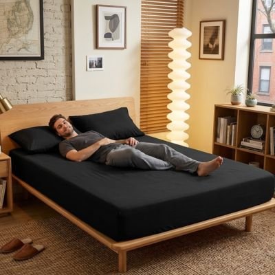 homme relaxant sur lit sur drap housse