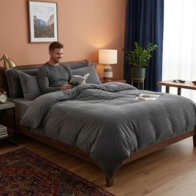 homme souriant assis lisant livre avec housse de couette flanelle