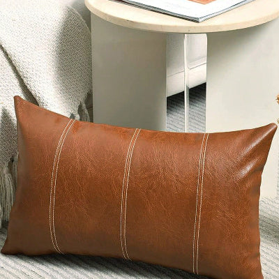 housse de coussin 30x50 simili déposé devant table chevet