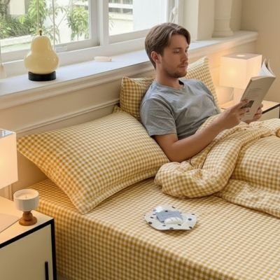 jeune homme adossé sur taie doreiller lisant dans son lit