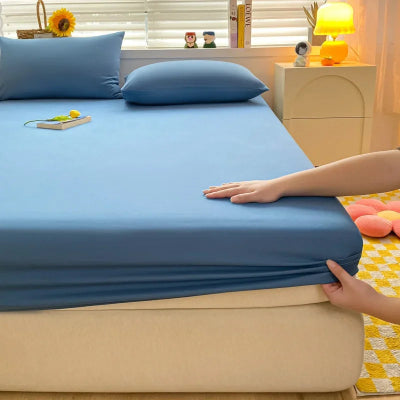 personne ajoutant draps housse bleu sur matelas