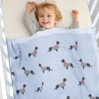 petit garçcon joyeux avec couverture bébé tricot