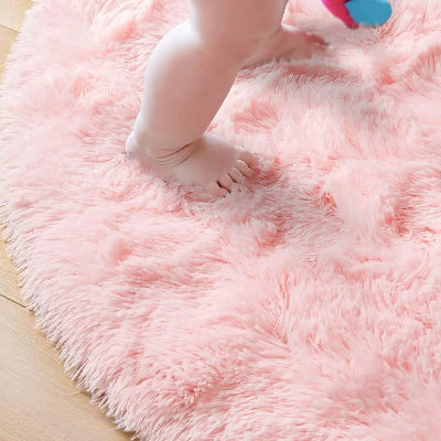 pieds bébé sur tapis rond rose