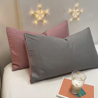 taie doreiller réversible bicolore rose et grise sur lit