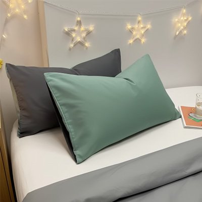 taie doreiller réversible bicolore verte et grise sur lit